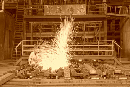 TANGSHAN - JUNE 20: Workers cutting steel ingot behind the continuous casting machine in steel plant, on June 20, 2014, Tangshan city, Hebei Province, Chinaのeditorial素材