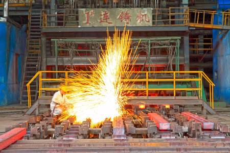TANGSHAN - JUNE 20: Workers cutting steel ingot behind the continuous casting machine in steel plant, on June 20, 2014, Tangshan city, Hebei Province, Chinaのeditorial素材