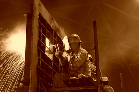 TANGSHAN - JUNE 19: workers welding mechanical parts in the workshop, on June 19, 2014, Tangshan city, Hebei Province, Chinaのeditorial素材