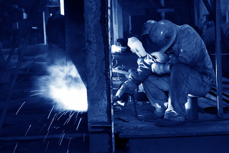TANGSHAN CITY - JUNE 20: Worker welding parts in the production workshop, on June 20, 2014, Tangshan city, Hebei Province, Chinaのeditorial素材