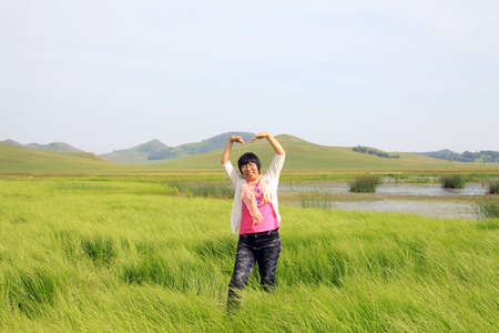 WULANBUTONG GRASSLAND - JULY 18: A female visitors leisure in the WuLanBuTong grassland on July 18, 2014, Inner Mongolia autonomous region, China. のeditorial素材