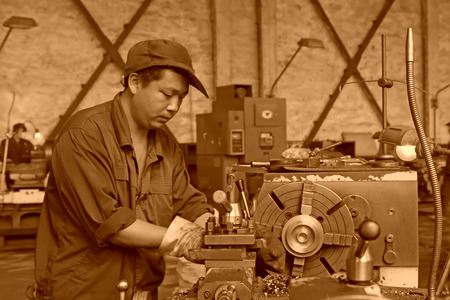 TANGSHAN CITY - JUNE 20: worker working in the machine tool in the production workshop, on June 20, 2014, Tangshan city, Hebei Province, Chinaのeditorial素材