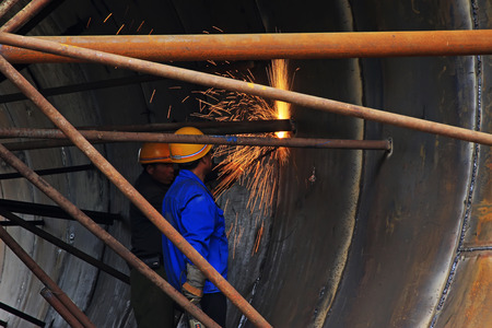 TANGSHAN - JUNE 20: Workers are welding metal components in a steel plant, on June 20, 2014,...
