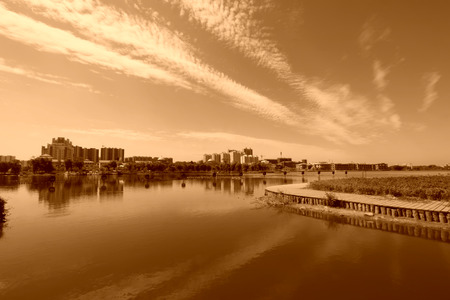 Wide water surface and high rise buildings in a parkの写真素材