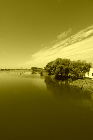 Wide water surface and buildings in a parkの写真素材