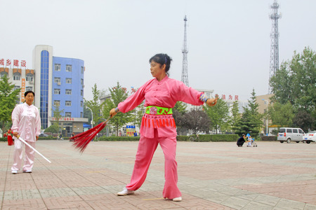 LUANNAN COUNTY - SEPTEMBER 20: Old woman Fencing performance in a square on September 20, 2014, Luannan county, Hebei Province, Chinaのeditorial素材