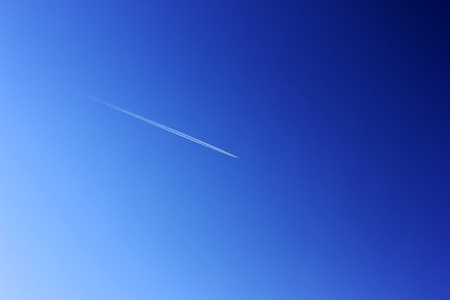 jet plane in blue sky, closeup of photoの写真素材