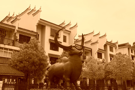 Phoenix County, April 15: Bull sculpture and architecture on April 15, 2012, Phoenix County, Hunan Province, Chinaのeditorial素材
