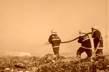 TANGSHAN - NOVEMBER 20: The words "Hebei fire" and "tangshan fire" on the clothes, the fireman at the scene of the fire, November 20, 2013, tangshan city, hebei province, China.のeditorial素材