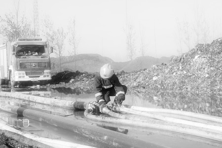 TANGSHAN - NOVEMBER 20: The firemen were control remote water supply pipeline in the scene of fire fighting and rescue work, November 20, 2013, tangshan city, hebei province, China.のeditorial素材