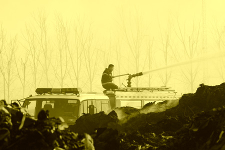 TANGSHAN - NOVEMBER 20: firefighters in sprinkler at the scene of the fire, November 20, 2013, tangshan city, hebei province, China.のeditorial素材