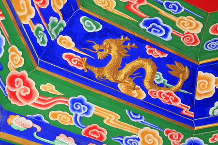 colored drawing gold dragon on wooden board, closeup of photoのeditorial素材