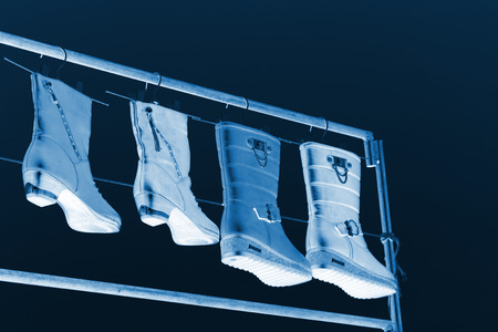 women's boots hanging in the blue sky, closeup of photoの写真素材