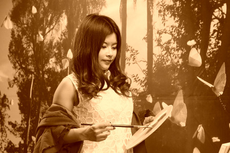 FENGNAN CITY - MARCH 30: A white skirt female model adjustment color with palette, March 30, 2014, Fengnan city, hebei province, China.のeditorial素材