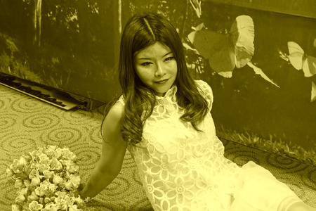 FENGNAN CITY - MARCH 30: A white skirt female model lying on the carpet, March 30, 2014, Fengnan city, hebei province, China.のeditorial素材