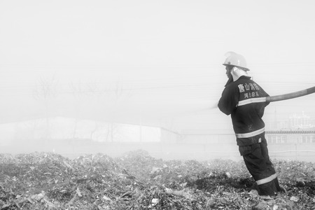 TANGSHAN - NOVEMBER 20: The words "Hebei fire" and "tangshan fire" on the clothes, the fireman at the scene of the fire, November 20, 2013, tangshan city, hebei province, China.のeditorial素材
