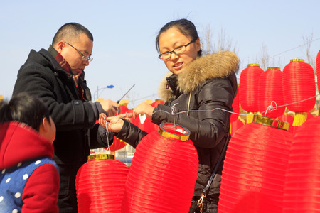 LUANNAN COUNTY - MARCH 5: On the Lantern Festival Day, People were busy with hanging red lanterns in a park, March 5, 2015, luannan county, hebei province, Chinaのeditorial素材