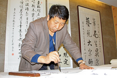 Luannan county - April 9: calligrapher Wangxiaomin writing calligraphy, April 9, 2015, luannan county, hebei province, Chinaのeditorial素材