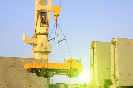 Heavy trucks are lifting to the cargo ship, closeup of photoのeditorial素材