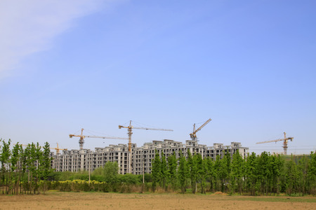 Unfinished buildings and tower crane, closeup of photo