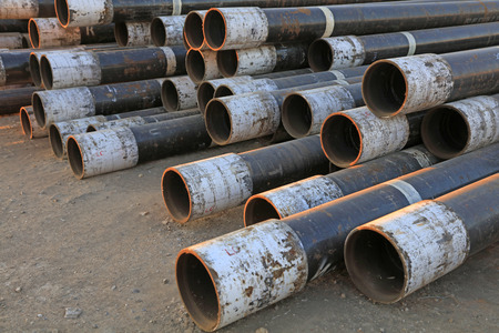Mottled steel pipe pile up together in a factory, closeup of photo