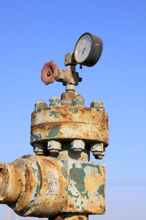 Oil pipeline control handwheel and pressure gage, closeup of photoのeditorial素材