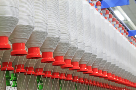 Spinning machinery parts and cotton yarn in the factory, closeup of photo