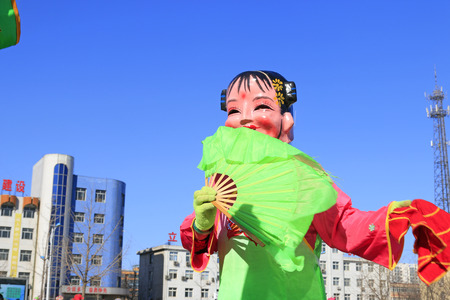Chinese traditional style yangko folk dance girl mask in the street, luannan County, hebei Province, Chinaのeditorial素材
