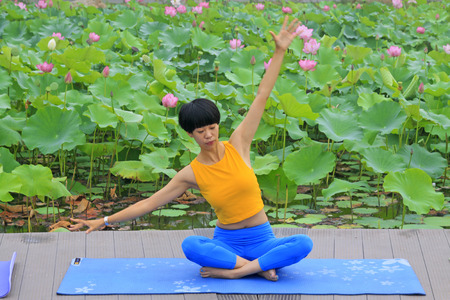 Luannan county - July 25: a woman doing yoga exercise in the park, on July 25, 2015, luannan county, hebei province, Chinaのeditorial素材