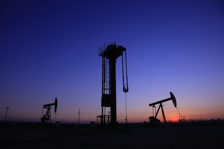 Tower type pumping unit under the setting sun in a oilfieldの写真素材