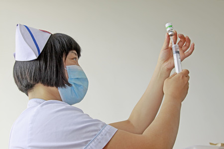 Luannan County - June 18th: a doctor being configured for injection, June 18th, 2015, Luannan County, Hebei Province, Chinaのeditorial素材
