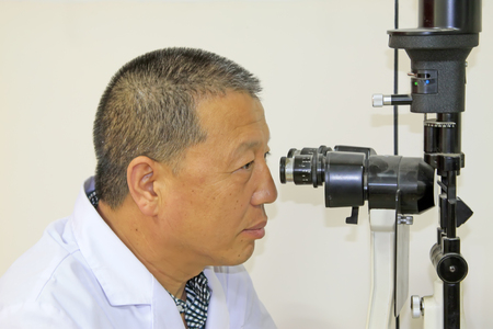 Luannan County - June 18th: a doctor examining the fundus of patients, June 18th, 2015, Luannan County, Hebei Province, Chinaのeditorial素材