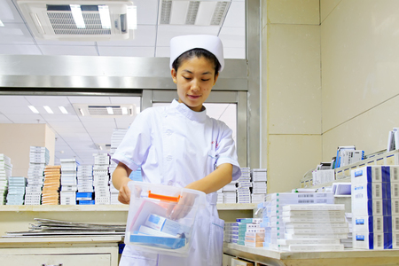 Luannan County - June 18th: a nurse taking medicine, June 18th, 2015, Luannan County, Hebei Province, Chinaのeditorial素材
