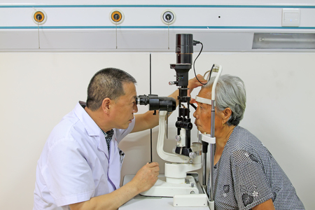 Luannan County - June 18th: a doctor examining the fundus of patients, June 18th, 2015, Luannan County, Hebei Province, Chinaのeditorial素材
