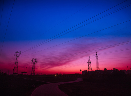 Electric power tower under the setting sunの写真素材
