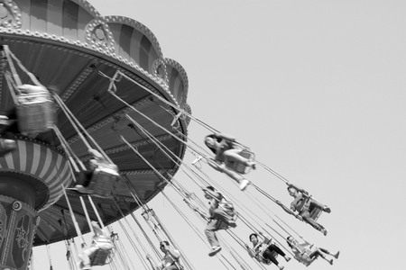 people on rotating facilities in a playground, closeup of photoのeditorial素材