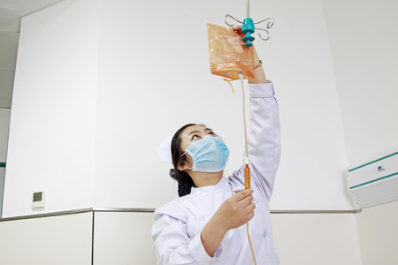 Luannan - June 29: nurse checking infusion tube, on June 29, 2015, luannan county, hebei province, Chinaのeditorial素材