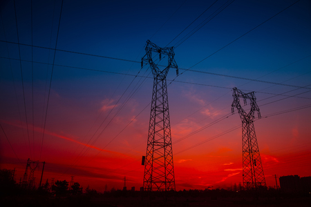Electric power tower under the setting sunの写真素材