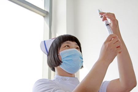 Luannan County - June 18th: a doctor being configured for injection, June 18th, 2015, Luannan County, Hebei Province, Chinaのeditorial素材