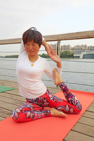 Luannan County - September 17, 2016: Woman practicing yoga in the park, Luannan County, Hebei Province, China.のeditorial素材