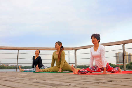 Luannan County-September 17, 2016: yoga exercise women in the park, Luannan County, Hebei Province,...