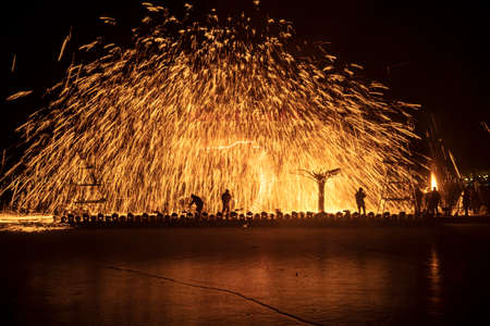 Chinese craftsmen spin hot iron melt at high speed, performing in the darkness, which is a traditional cultural heritageの写真素材