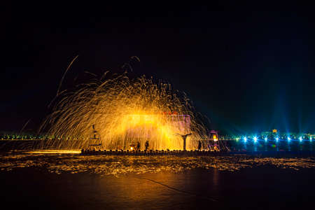 Chinese craftsmen spin hot iron melt at high speed, performing in the darkness, which is a traditional cultural heritageの写真素材