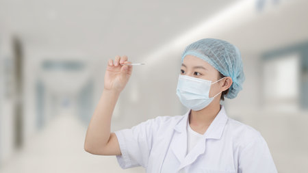 Image of nurse holding thermometer in hospitalの写真素材