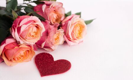 Red roses and heart shape ornaments on white backgroundの写真素材