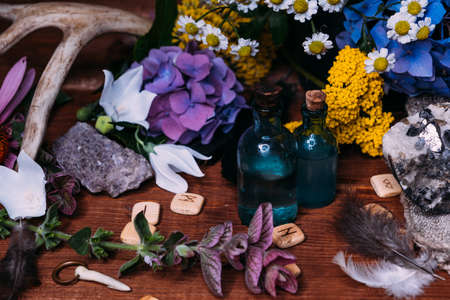 Magic potion bottle. Witchcraft halloween concept with potions, herbs and occult equipment. Magical still life with copy space on a dark background.の写真素材