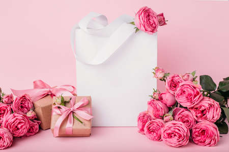 Mock up Composition paper bag, gift boxes and pink roses, for St. Valentine's Day with a place for your text. photo mock up on pink background