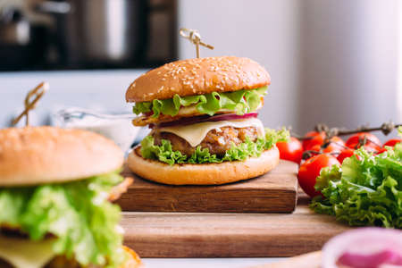 Two home made fresh tasty burgers with lettuce and cheese.の写真素材