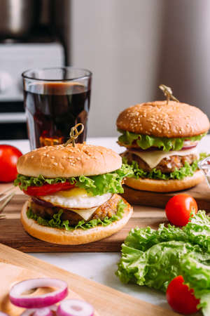 Two home made fresh tasty burgers with lettuce and cheese.の写真素材