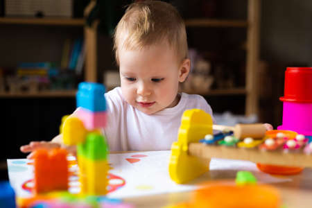 Cute little girl playing alone with many colorful toysの写真素材